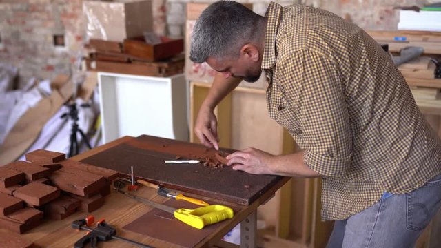 Hardworking crafsman works on small wooden boat