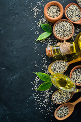 Seeds of sesame and sesame oil. On the old background. Top view. Free copy space.
