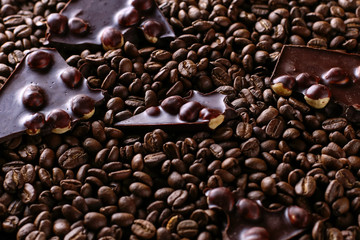 Spilled coffee grains and black chocolate, delicious background.