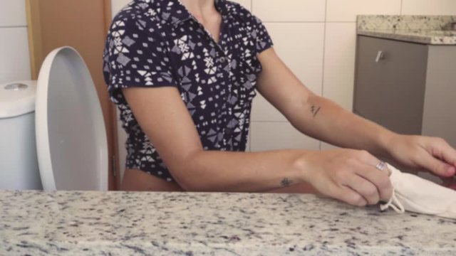 medium shot of woman putting natural tampons in bathroom