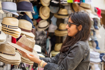 Young indian woman buying hats