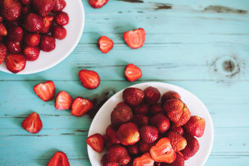 Strawberries in the white plate on the white wooden background, strawberries on wooden table background,  top view