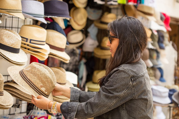 Fototapeta na wymiar Young indian woman buying hats