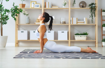 woman doing yoga, meditating in Lotus position at home