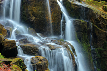 Fototapeta premium streams and cascades of waterfall. beautiful nature background. huge mossy wet rocks. close up shot