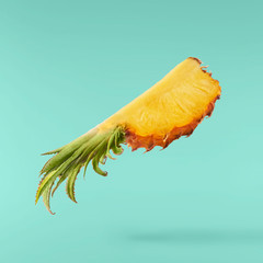 Flying in air fresh ripe whole and cut baby Pineapple with slices and leaves