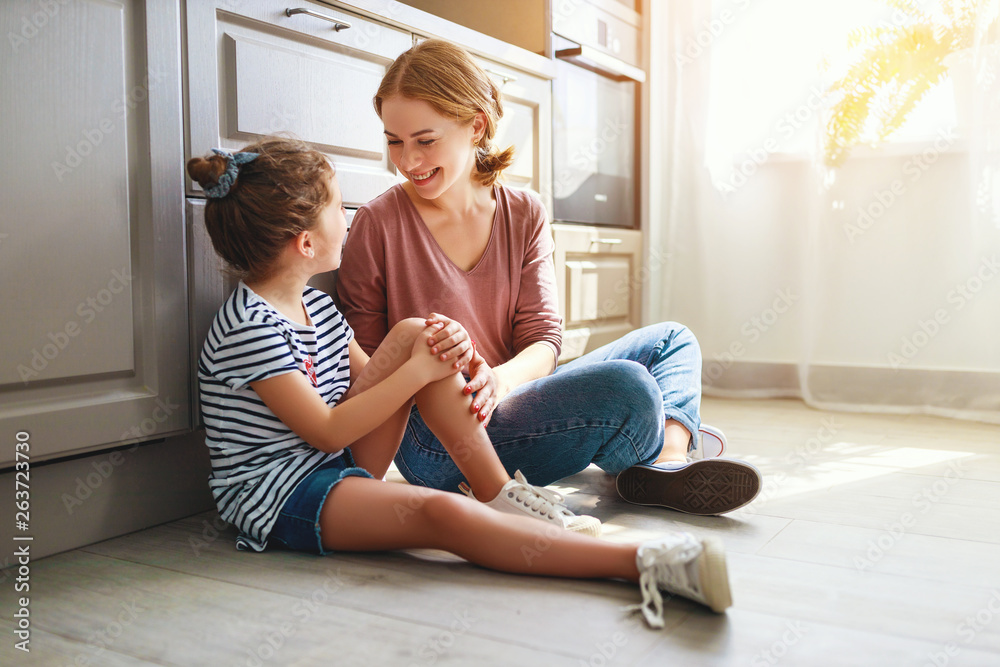 Wall mural family mother and child daughter hugging in kitchen on floor