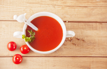Fresh delicious homemade tomato soup on the wooden table. Top view.
