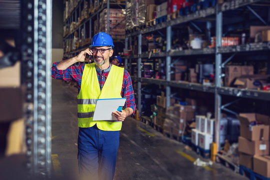 Warehouse Worker Talking On The Phone Holding Clipboard 