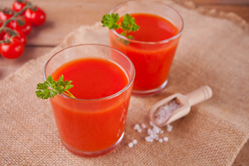 Tomato juice with parsley and salt on the jute napkin