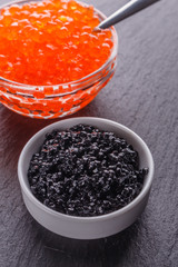 red and black caviar in a bowl on a dark stone background