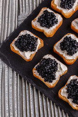 Snack with red and black caviar on a stone plate