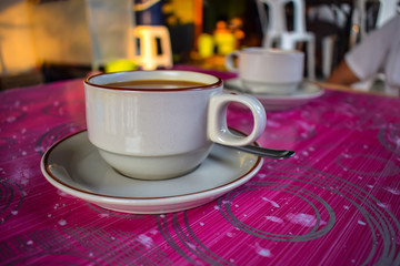 Coffee on the pink table is inside the walking market.