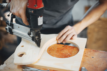 A man carves a tree. The carpenter works in a studio. An engineer provides a tree shape