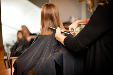 Obraz na płótnie Canvas Red-Haired Girl Getting Haircut in Hair Salon