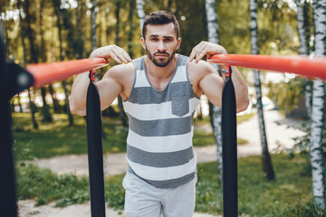 Obraz premium Handsome man in a park. Sportsman in a sportswear. Guy training 