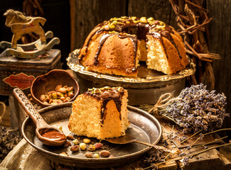cake with chocolate and pistachios on a wooden background in vintage style