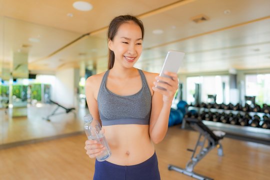 Portrait Beautiful Asian Young Woman Using Mobile Phone In Gym