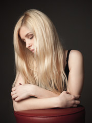 Fototapeta premium Portrait of the attractive blonde young woman on black background.