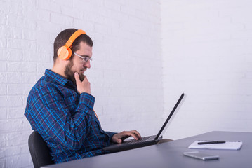 Freelancer working on a laptop in bright headphones, remote work.