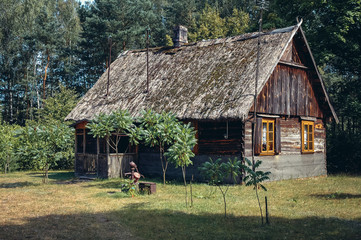 Fototapeta na wymiar Old wooden house with thatched roof in a small village in Wegrow County in Masovian Voivodeship of Poland