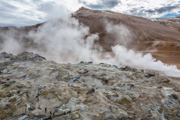 Steam in Hverir geothermal area with boiling mudpools and steaming fumaroles in Iceland
