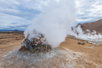 Steaming cone in Hverir geothermal area with boiling mudpools and steaming fumaroles in Iceland