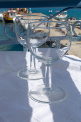 Two empty wine glasses on table outside on balcony  with sea view