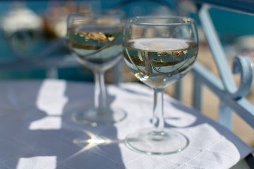 White wine served outside on balcony on glass table with sea view