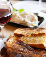 Greek food, roasted bread with olive oil and herbs, red wine and tzatziki sauce