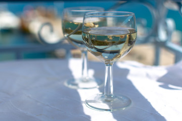 White wine served outside on balcony on glass table with sea view