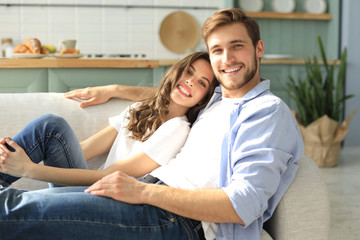 Portrait of cute young couple sitting in sofa.