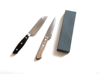 Kitchen knife and sharpening stone on a white background- image