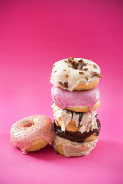 Stack of donuts on bright pink background