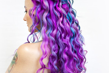 Fototapeta premium Delightfully bright colored hair, multi-colored coloring on long hair. The stylish, contemporary styling of curls.