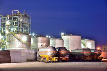 The oil truck tankers in the refinery background in the evening