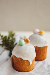 Happy Easter background with an easter bread cake decorated with glaze, chocolate and  eggs. For greeting card, ad, promotion, poster, flyer. complex composition, beautiful scenery, movement, hands