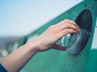 Young woman recycling glass bottle