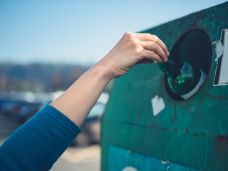 Young woman recycling glass bottle