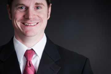 Young Businessman in Suit on Black Background