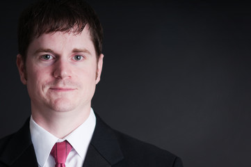 Young Businessman in Suit on Black Background