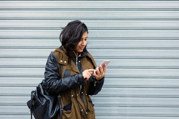 young indian woman using mobile phone in the city