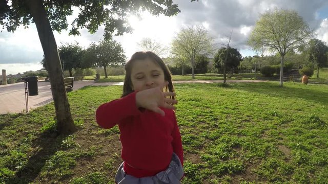 4k Little girl greeging at park, cute child girl in natura say hi in joy and happiness