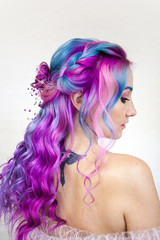 Fototapeta premium Portrait of a young beautiful woman with colored hair. Bright shades of blue and purple, gradient hair.
