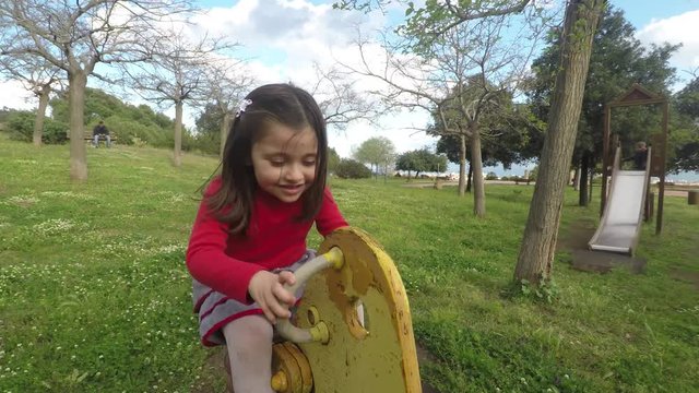 4k Little girl at park playing with wood horse, cute happy child girl having fun in nature