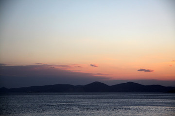 Obraz premium Sunset or sunrise on the sea and mountains in the background. Bright sky. Beautiful seascape.