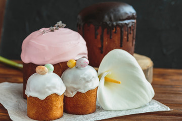 Happy Easter background with an easter bread cake decorated with glaze, chocolate and  eggs. For greeting card, ad, promotion, poster, flyer. complex composition, beautiful scenery, movement, hands