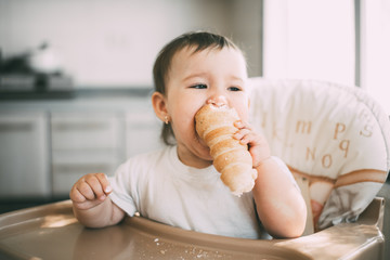 baby in the kitchen eagerly eating the delicious cream horns, filled with a vanilla cream