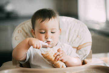baby in the kitchen eagerly eating the delicious cream horns, filled with a vanilla cream