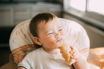 baby in the kitchen eagerly eating the delicious cream horns, filled with a vanilla cream